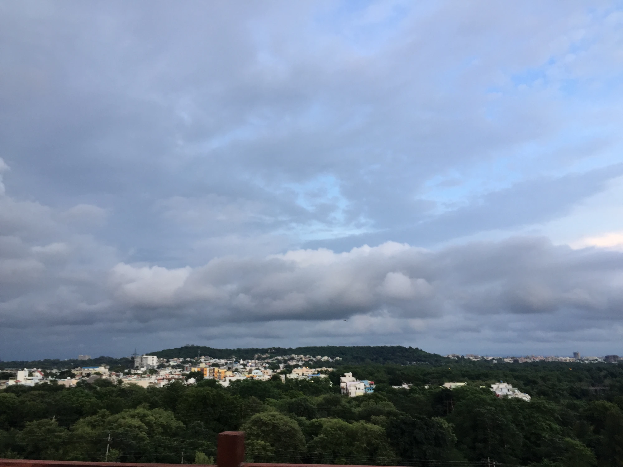 Storm clouds gathering over a distant city skyline