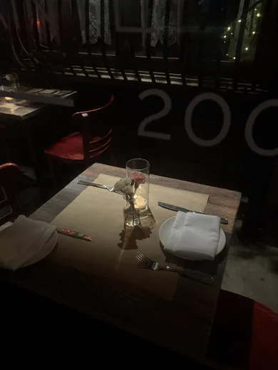 A dark restaurant table with the year 2001 on the wall