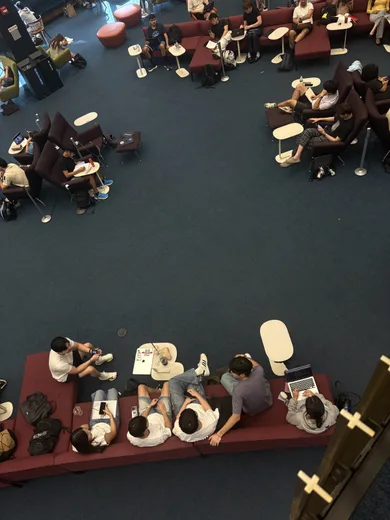 A busy room full of people at tables, seen from above