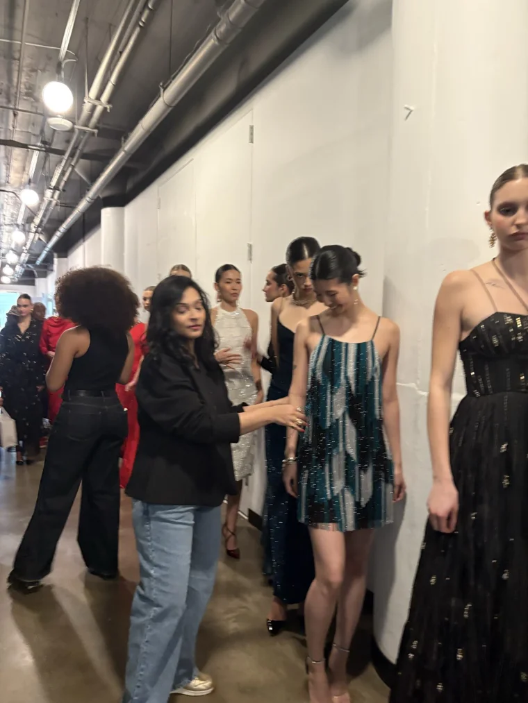 Models lined up while a team member adjusts a look