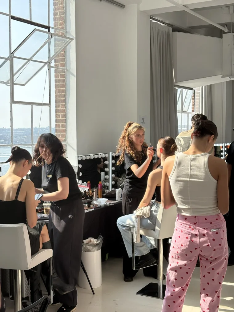 Backstage hair and makeup stations with models getting ready