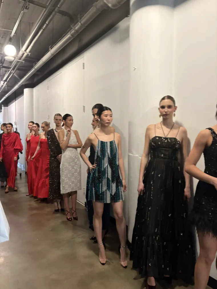 Models lined up in a corridor before walking the runway